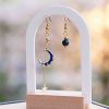 Boucles d’oreilles asymétriques Lunaria en acier inoxydable doré avec lune et zircon